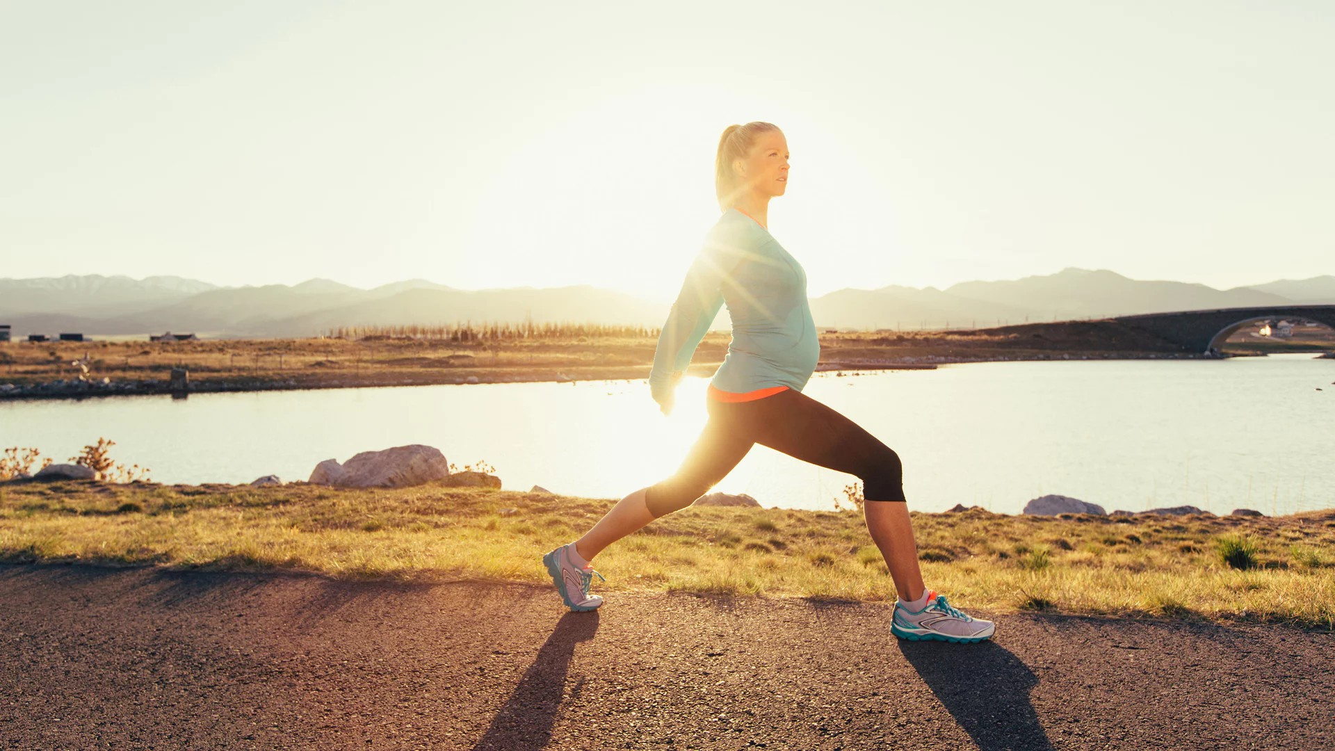 Frau in Laufkleidung. Im Hintergrung Wasser.